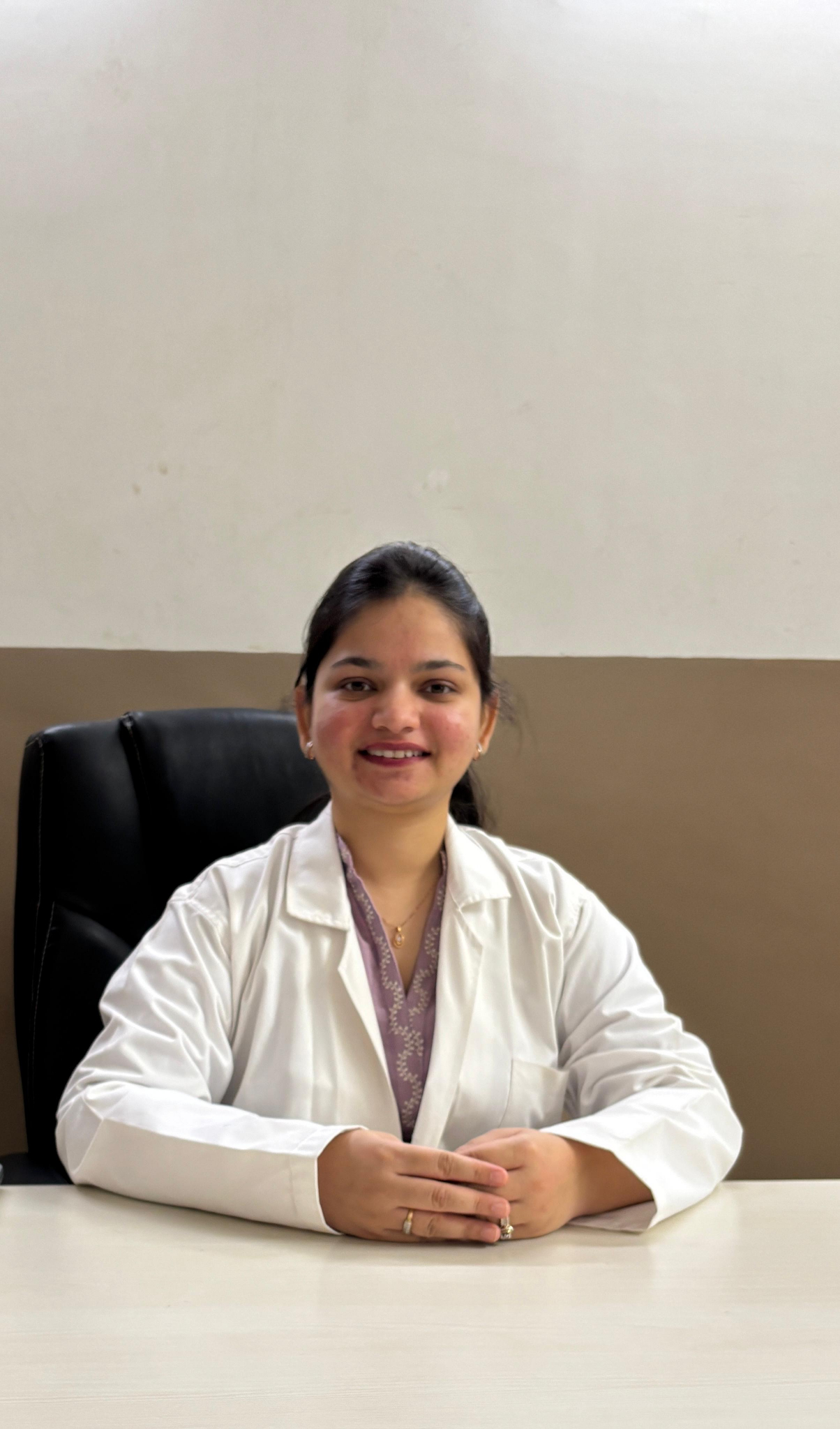 Dr. Tanushi Tambi seated in a clinical consultation setting